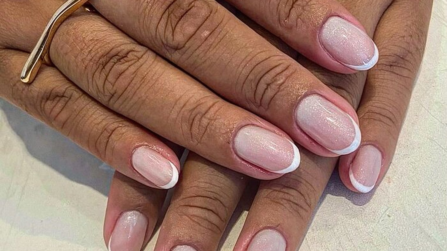 Francesinha clássica em unhas curtas naturais, ponta branca fina sobre base nude — trabalho de Priscila Dias